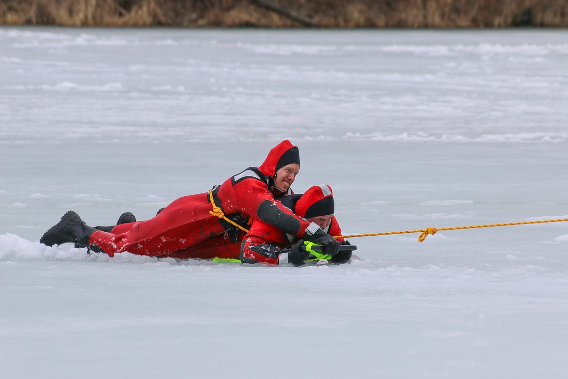 Photo by MANDI BATEMAN
Hall Mountain Volunteer Firefighters Ben Allinger and Ben Huff practice a technique utilizing a board to drag victims from the ice.