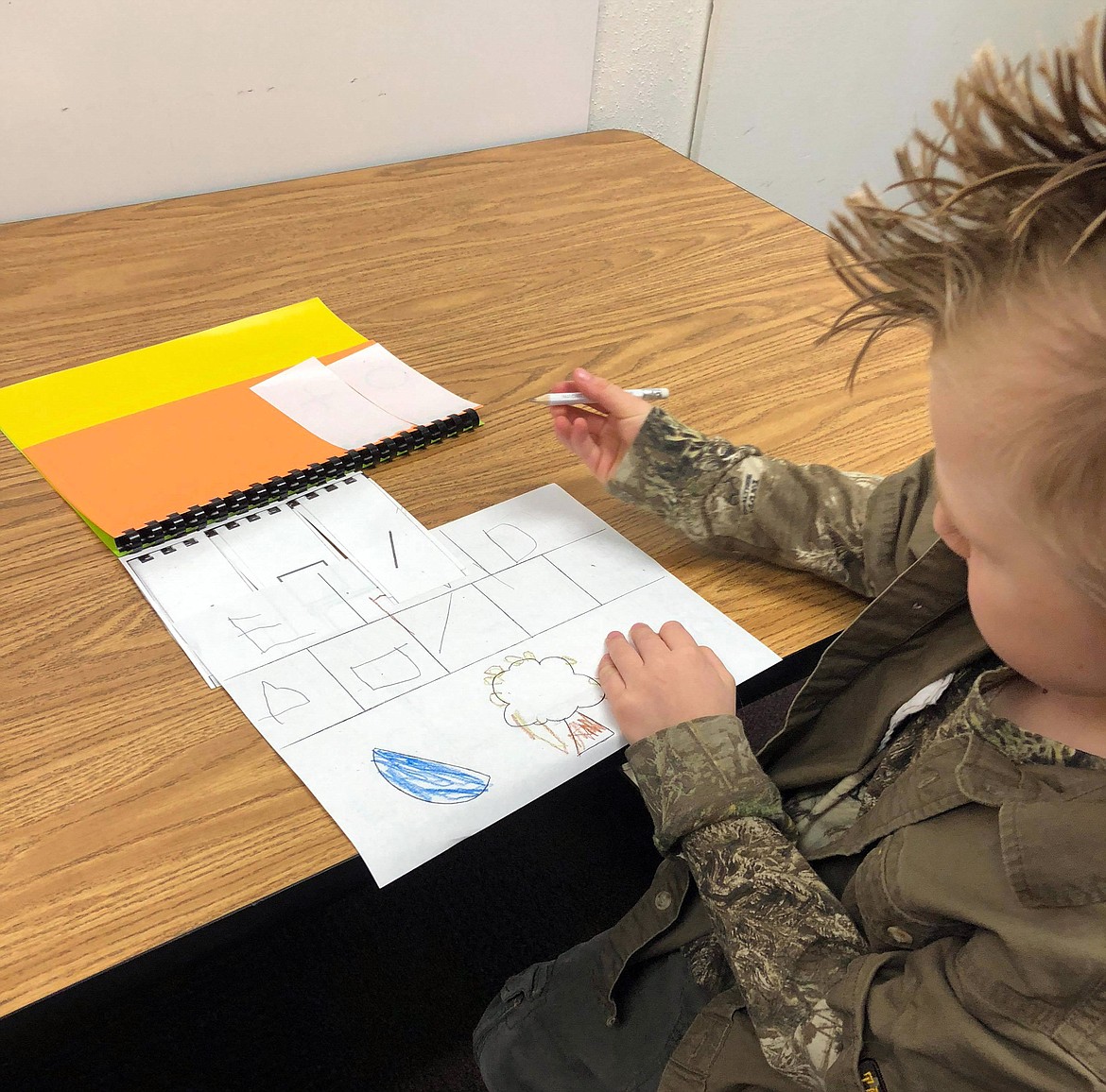 Malachi shows Thompson Falls Elementary teacher Emmalie Gavlak how he can draw shapes and a pine cone.