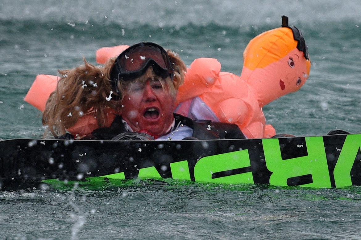 Johnathan Cook, dressed as President Donald Trump and Stormy Daniels, swims across the pond after a crash at the 2018 Whitefish Pond Skim at Whitefish Mountain Resort on Saturday. (Casey Kreider/Daily Inter Lake)