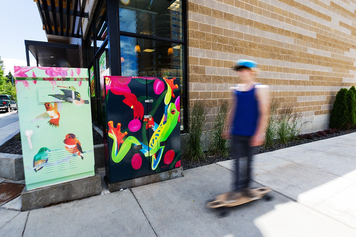 (SHAWN GUST/Hagadone News Network file) 
A long board rider zooms in 2014 along the sidewalk near a pair of utility boxes wrapped in art near the intersection of Seventh Street and Sherman Avenue in Coeur d&#146;Alene.