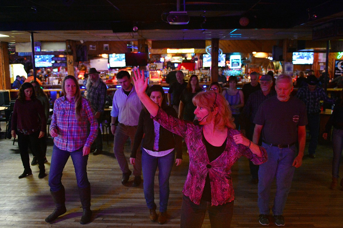 Dance teacher April Howard demonstrates a step to particpants at the Blue Moon Nite Club in Columbia Falls on Wednesday, March 28. (Casey Kreider/Daily Inter Lake)