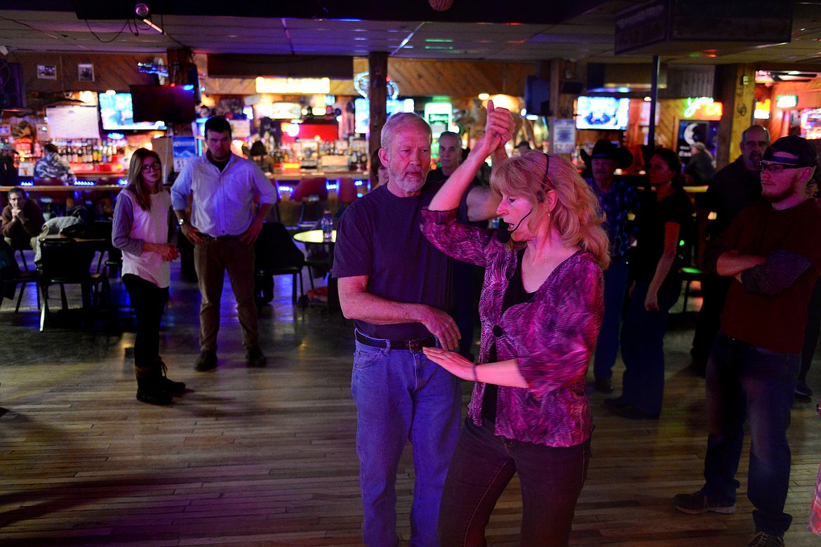 Dance teacher April Howard demonstrates a step with Roger Phillips, of Kalispell, at the Blue Moon Nite Club in Columbia Falls on Wednesday, March 28. (Casey Kreider/Daily Inter Lake)