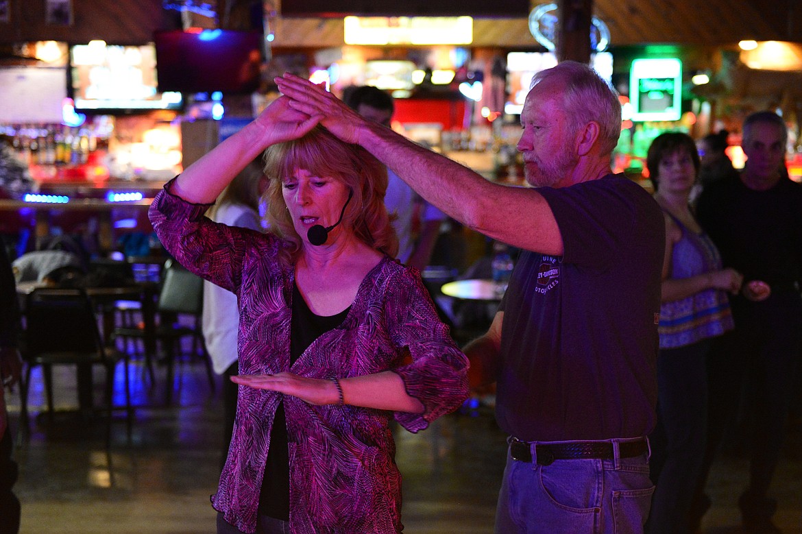 Dance teacher April Howard demonstrates a step with Roger Phillips, of Kalispell, at the Blue Moon Nite Club in Columbia Falls on Wednesday, March 28. (Casey Kreider/Daily Inter Lake)