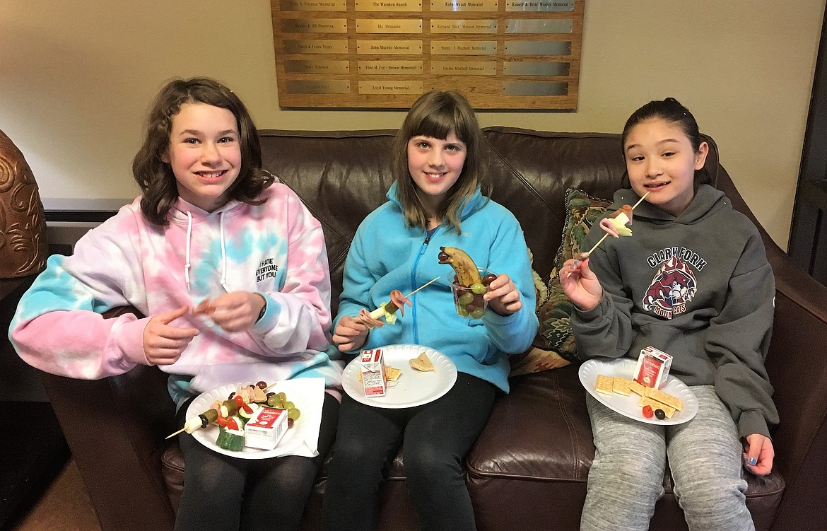 Alberton art students Raeleen Czerp, Kenzie Johnson, and Anna Dao enjoy snacks during an art reception at Mineral Community Hospital last month. (Photo by Monte Turner).