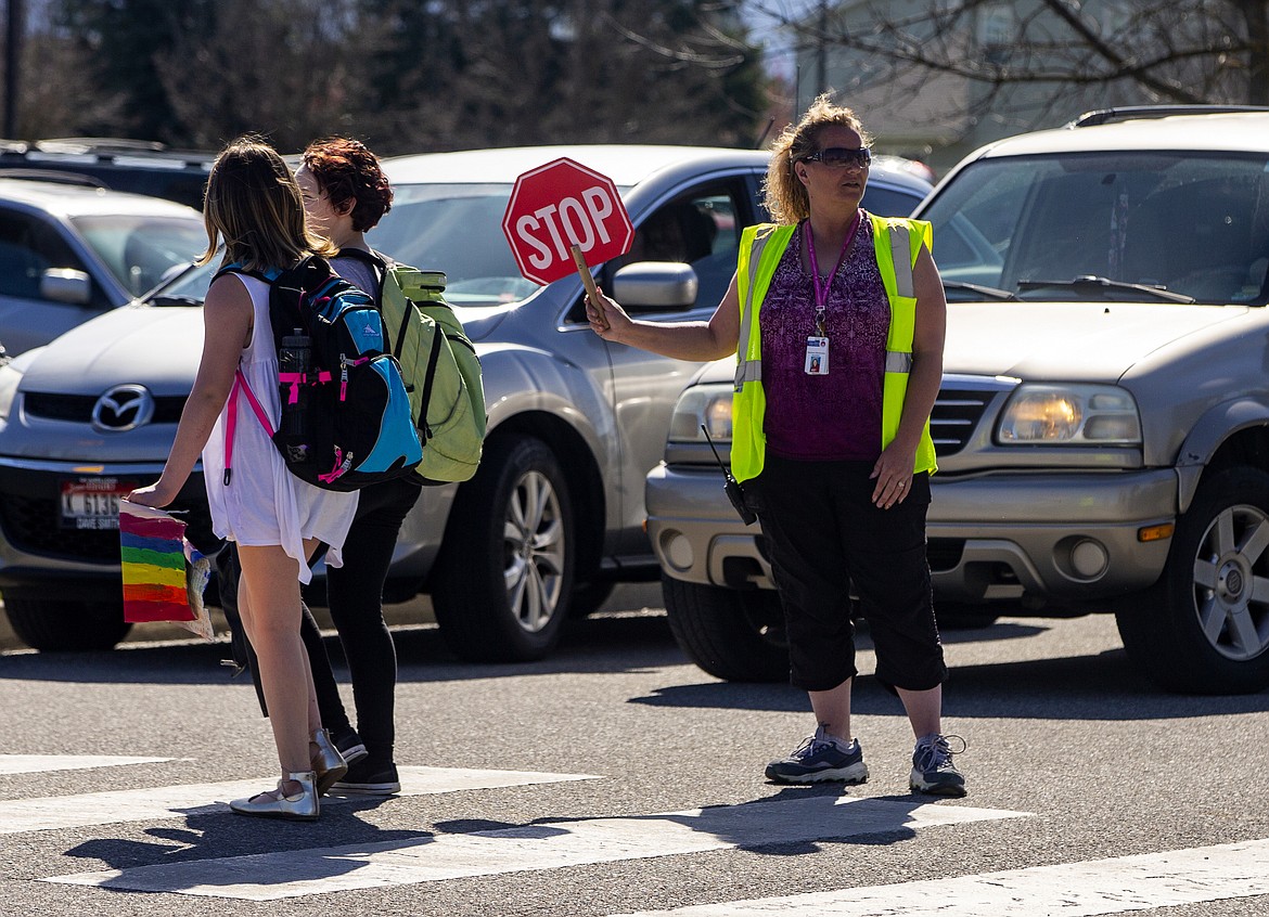A new 500-lot subdivision is planned for  land south of Prairie along Ramsey road and has raised concerns about after-school traffic and safety. Here, third-grade teacher Stephanie Blakenship stops traffic to allow students to cross the street Tuesday afternoon near Skyway Elementary School. (LOREN BENOIT/Press)