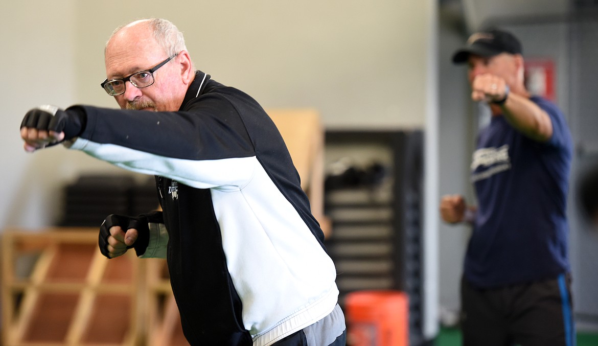 Dale Bax and volunteer Tim Gravelle, in background doing shadowboxing drills during the RockSteady Boxing for Parkinson&#146;s class on Wednesday morning, April 25, at Access Fitness in Kalispell.
(Brenda Ahearn/Daily Inter Lake)