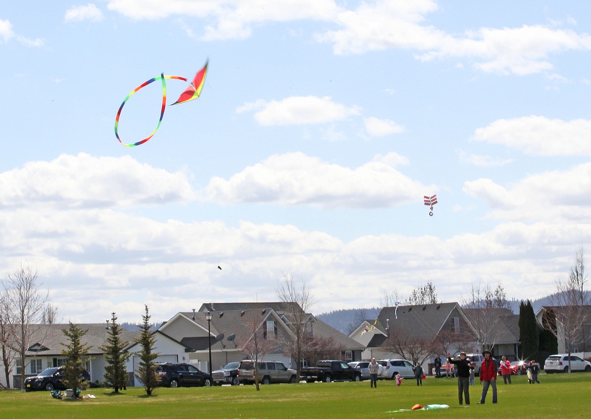 David Niemann, 13, of Hayden, directs his colorful trick kite with the assistance of his dad, Brad Niemann, during the annual kite festival in Hayden on Saturday. The Niemann kite zipped and swooshed through the sky, attracting spectators and an award from event judges. (DEVIN WEEKS/Press)