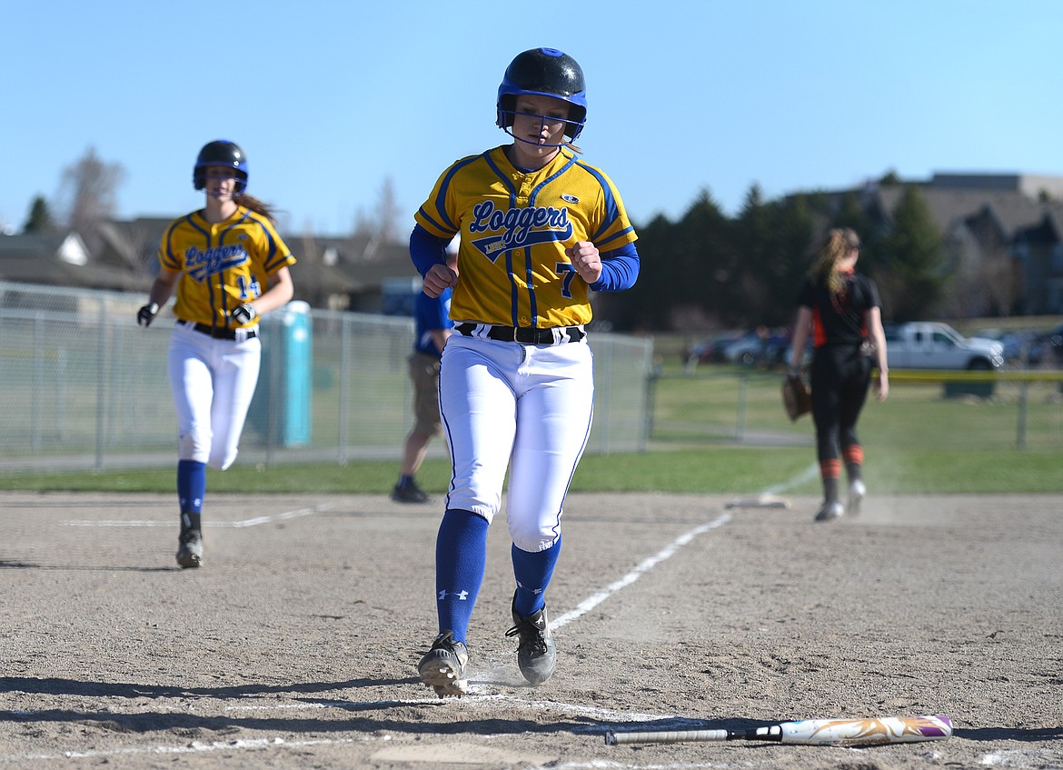 Libby's Khalyn Hageness (7) and Jayden Winslow (14) score on a first-inning, two-run double by Emily Carvey against Flathead on Tuesday. (Casey Kreider/Daily Inter Lake)