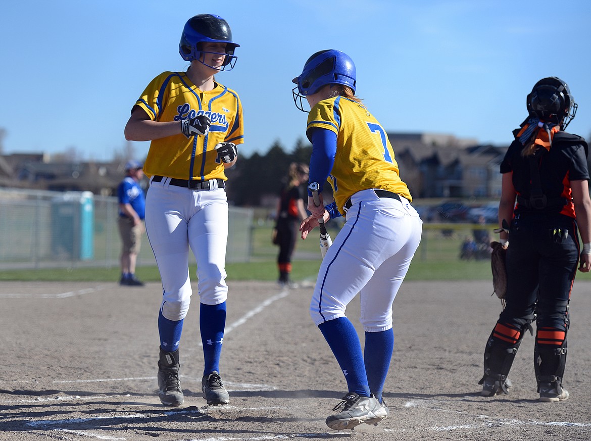 Libby's Jayden Winslow (14) and Khalyn Hageness (7) score on a first-inning, two-run double by Emily Carvey against Flathead on Tuesday. (Casey Kreider/Daily Inter Lake)