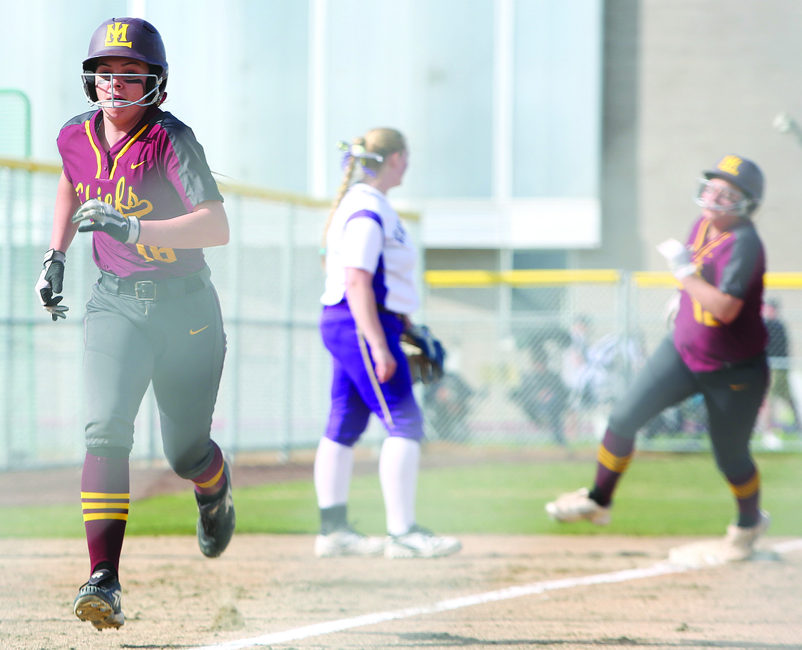 Connor Vanderweyst/Columbia Basin Herald
Moses Lake's Savannah Ashley (foreground) and Brooke Richardson come in to  score in the first inning against Wenatchee.