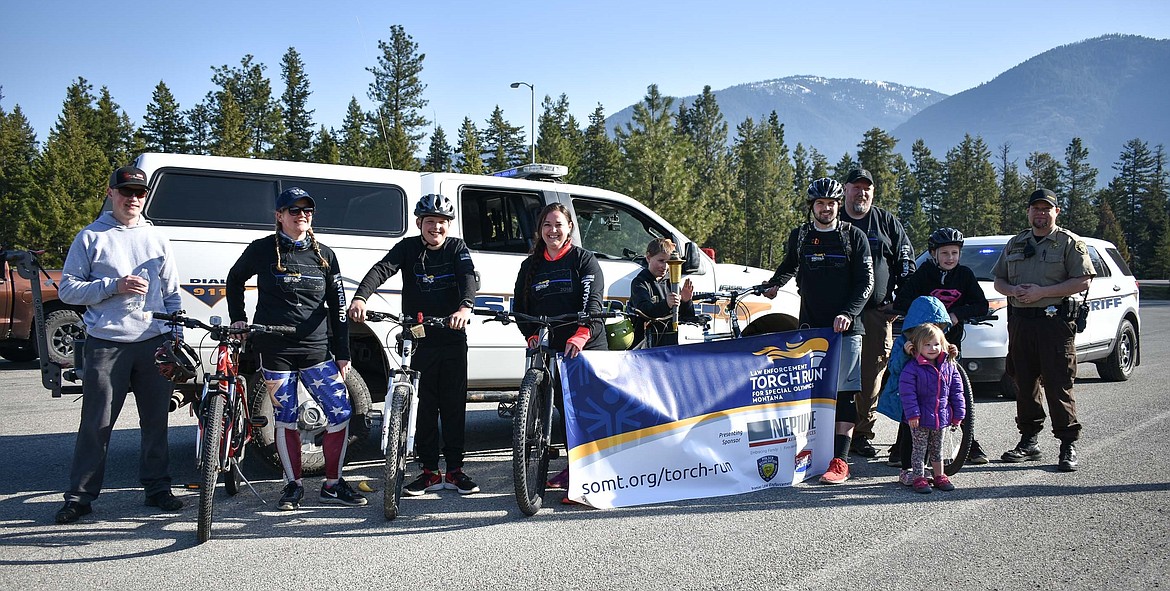 Law Enforcement Torch Run for Special Olympics participants who escorted the Special Olympics Torch from the Idaho border and through Troy pause at the weigh station east of town for a photo with the torch and banner before beginning the trek to Libby Wednesday. (Ben Kibbey/The Western News)