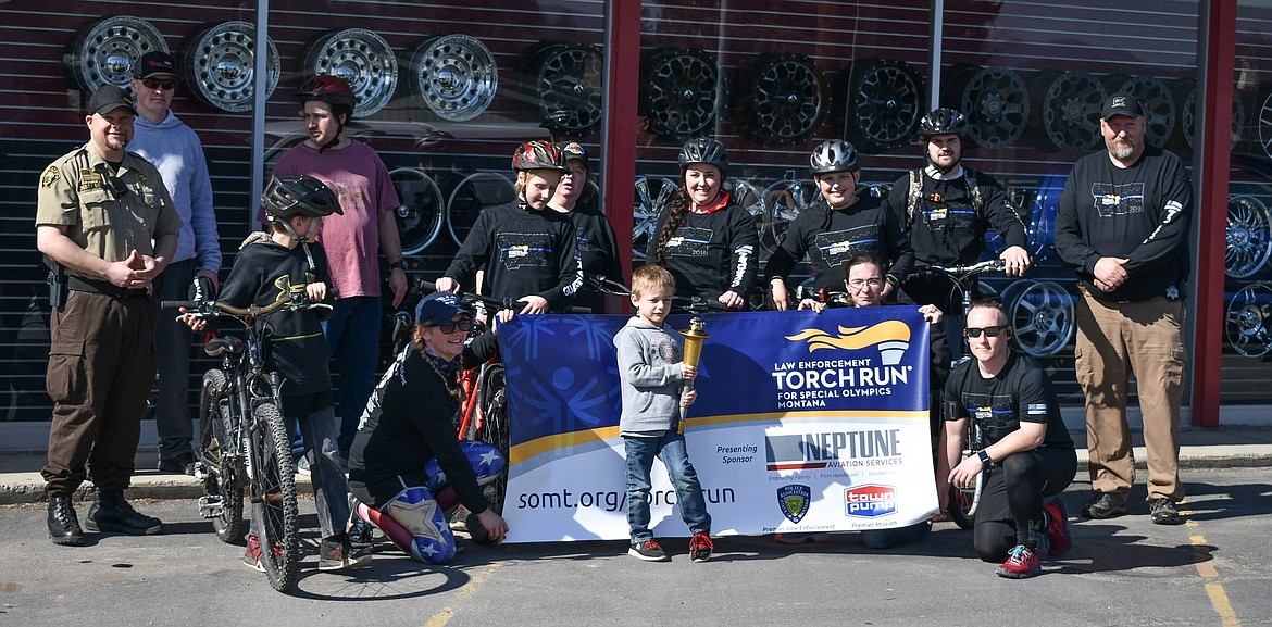 James Wiederhold, center, carried the torch through Libby, accompanied and flanked by local law enforcement and other community members during the annual Law Enforcement Torch Run for Special Olympics on Wednesday. (Ben Kibbey/The Western News)