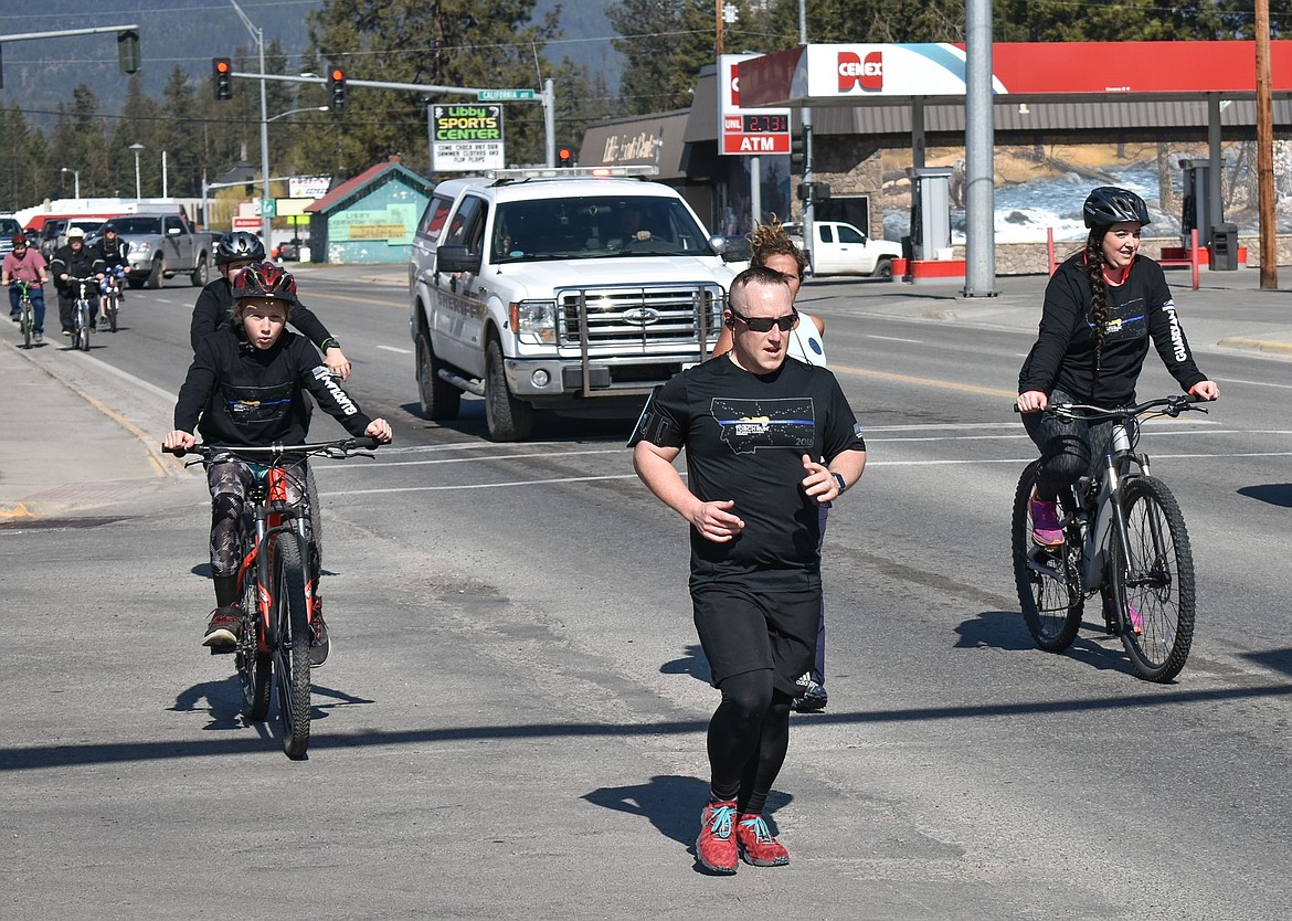 Libby Police Officer Cody DeWitt leads the annual Law Enforcement Torch Run for Special Olympics through Libby on Wednesday. (Ben Kibbey/The Western News)