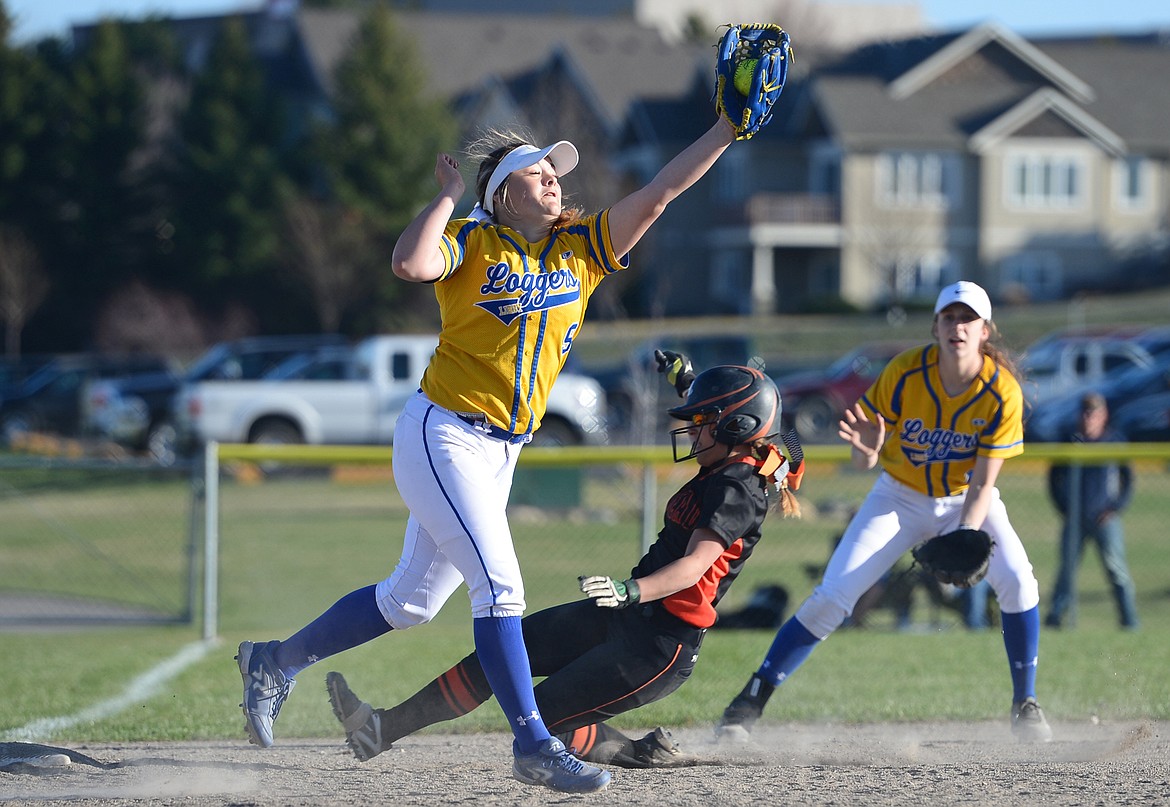 Flathead&#146;s Jayden Russell slides into third after a pitch in the dirt by Libby pitcher Khalyn Hageness. Applying the tag is Libby third baseman Emily Carvey. (Casey Kreider/Daily Inter Lake)