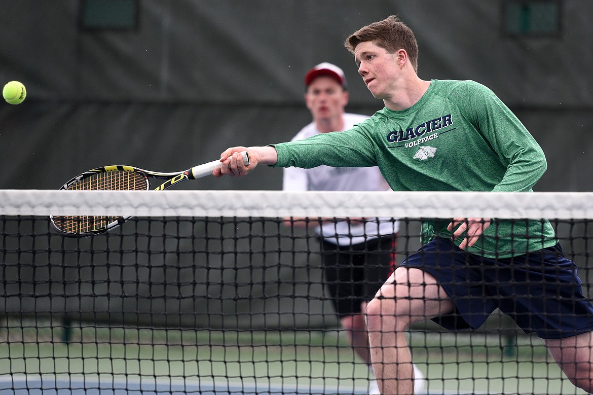 Glacier High School's Drew Engellant hits a return against Missoula Hellgate's doubles pairing of River Duce and Cole Tolleson-Knee at Flathead Valley Community College on Saturday. In the background is Engellant's doubles teammate Morgan Cordell. (Casey Kreider/Daily Inter Lake)