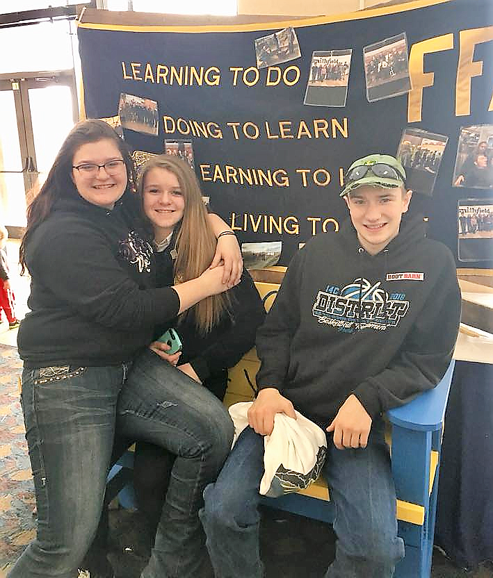 St. Regis FFA members Virginia English, Chloe Cielke, and Jacob Jasper pose by the FFA Motto, &#147;Learning to do, Doing to Learn, Earning to Live, Living to Serve&#148; while at the State Conference in Billings. (Photo courtesy of St. Regis FFA).