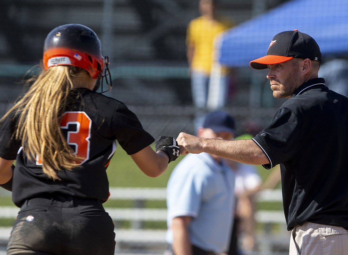 Bailey Gleaves gives her coach and father, Holly Gleaves, a fist bump as she rounds third base after homering against Lake City.