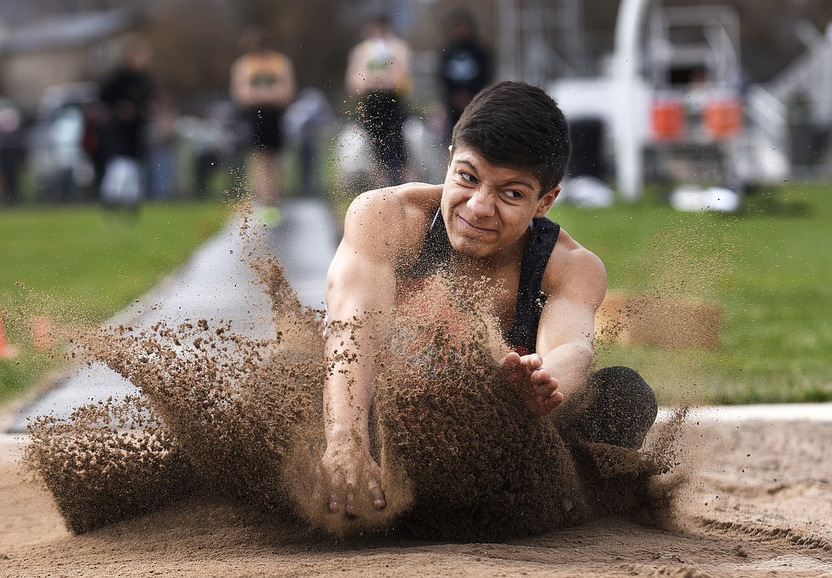 Flathead&#146;s Trae Vasquez crashes down in the sand during the long jump at a track meet against Whitefish at Legends Stadium on Tuesday. (Aaric Bryan/Daily Inter Lake)