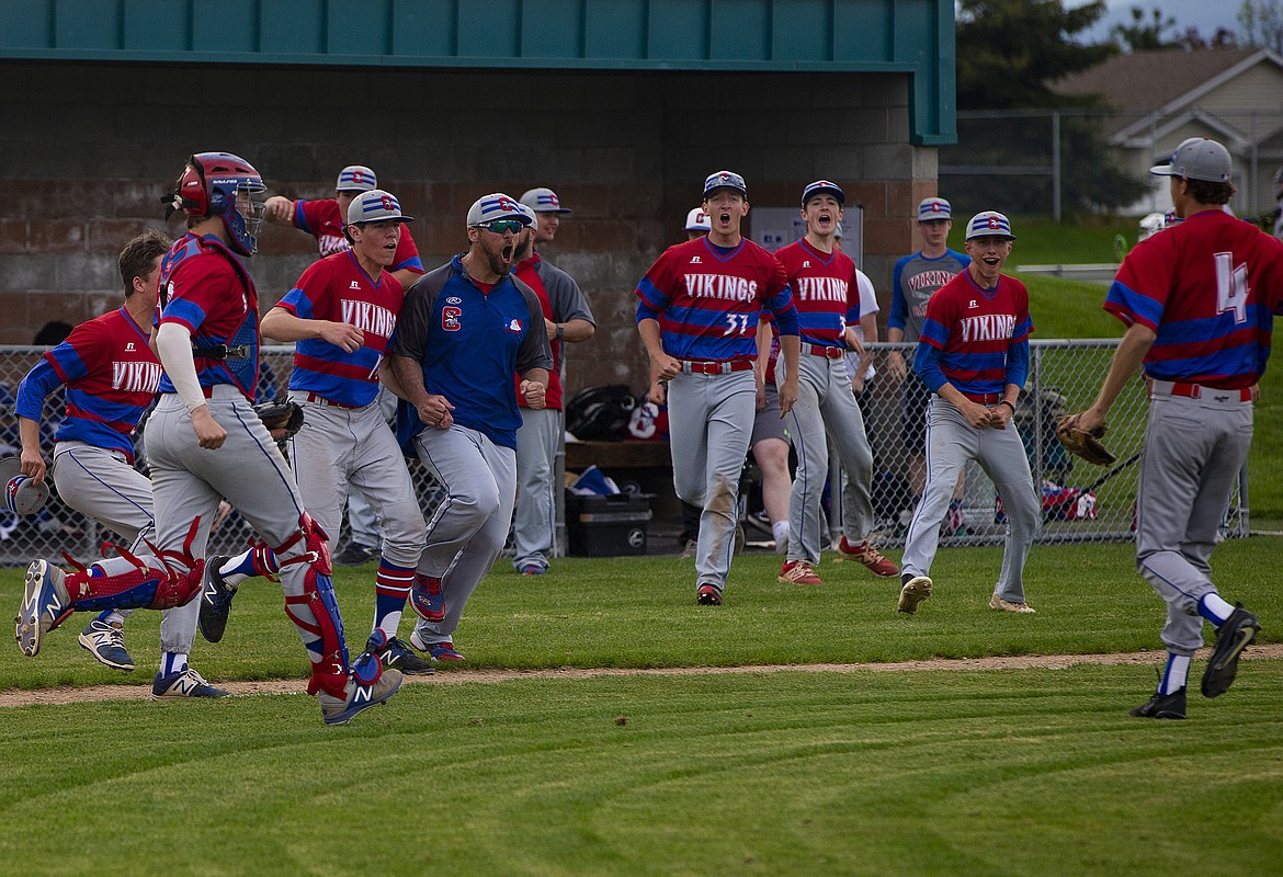 The Coeur d&#146;Alene High School baseball team rushes out of the dugout to celebrate their 3-2 win to eliminate No. 1 seed Lake City. (LOREN BENOIT/Press)