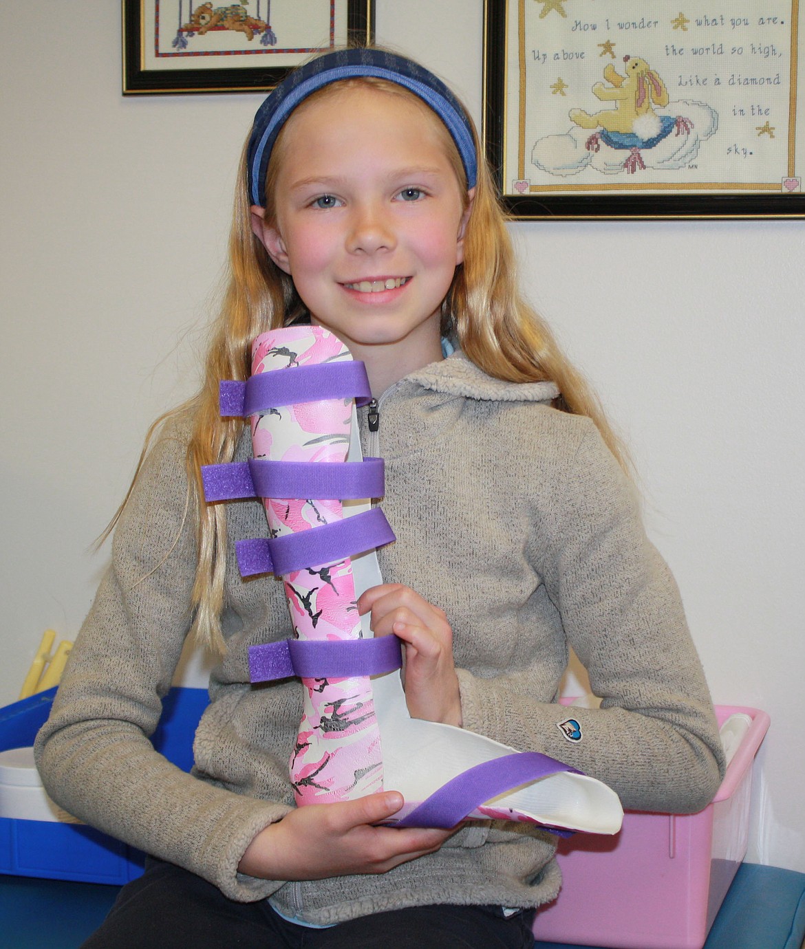 Emmaline Spyra, a fifth-grader at Sorensen Magnet School of the Arts and Humanities, showcases a clubfoot splint Thursday morning while on a tour of the physical therapy area of the Shriners Children's Hospital in Spokane. The kind-hearted young lady held two bake sales to raise $373 to donate to the hospital, which is one of the only local hospitals that has pediatric orthopedic surgeons who can correct clubfeet. (Courtesy photo)