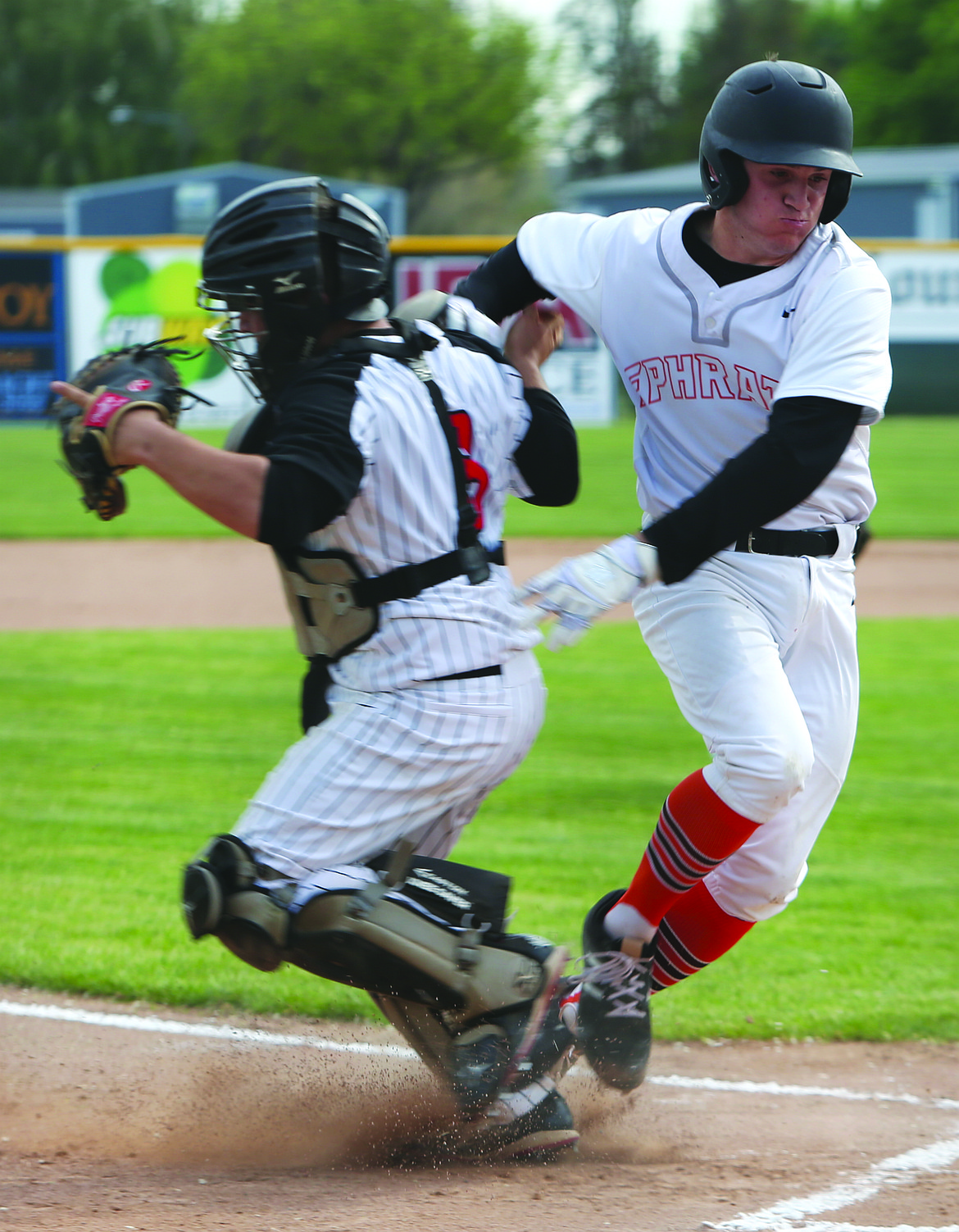 Connor Vanderweyst/Columbia Basin Herald
Ephrata's Zac Berryman (right) gets past Othello catcher Valente Garza to score in the first inning.