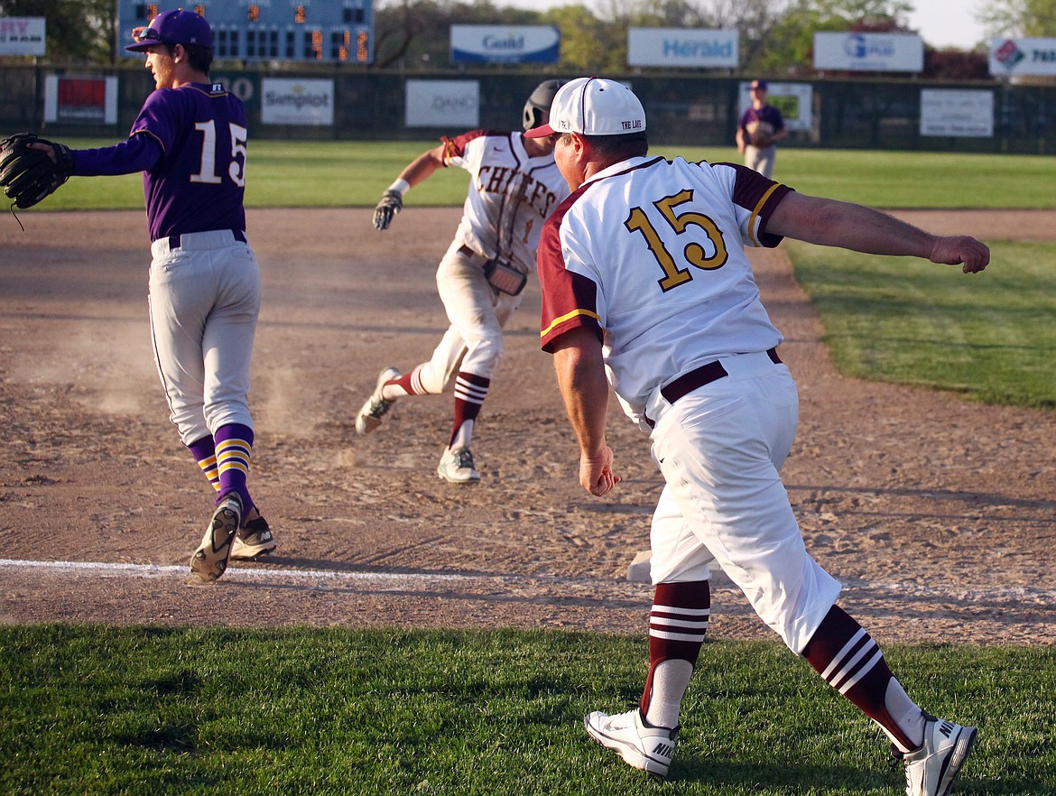 Rodney Harwood/Columbia Basin Herald
Donnie Lindgren (15) waves a runner around third base against Wenatchee at Larson Playfield.