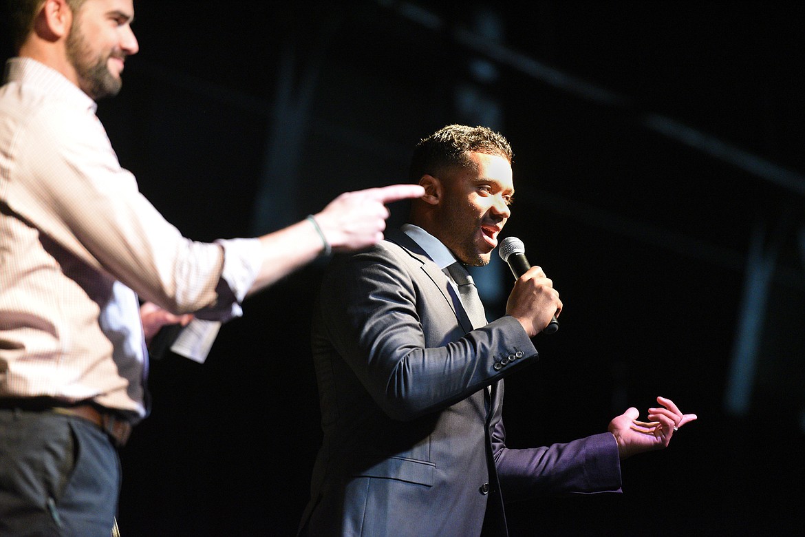 Seattle Seahawks quarterback Russell Wilson and Darnay Tripp lead the crowd in a &quot;S-E-A-H-A-W-K-S&quot; cheer at an event held by Stillwater Christian School at the Flathead County Fairgrounds in Kalispell on Wednesday. Tripp is sports director at KREM 2 in Spokane, Washington. (Casey Kreider/Daily Inter Lake)