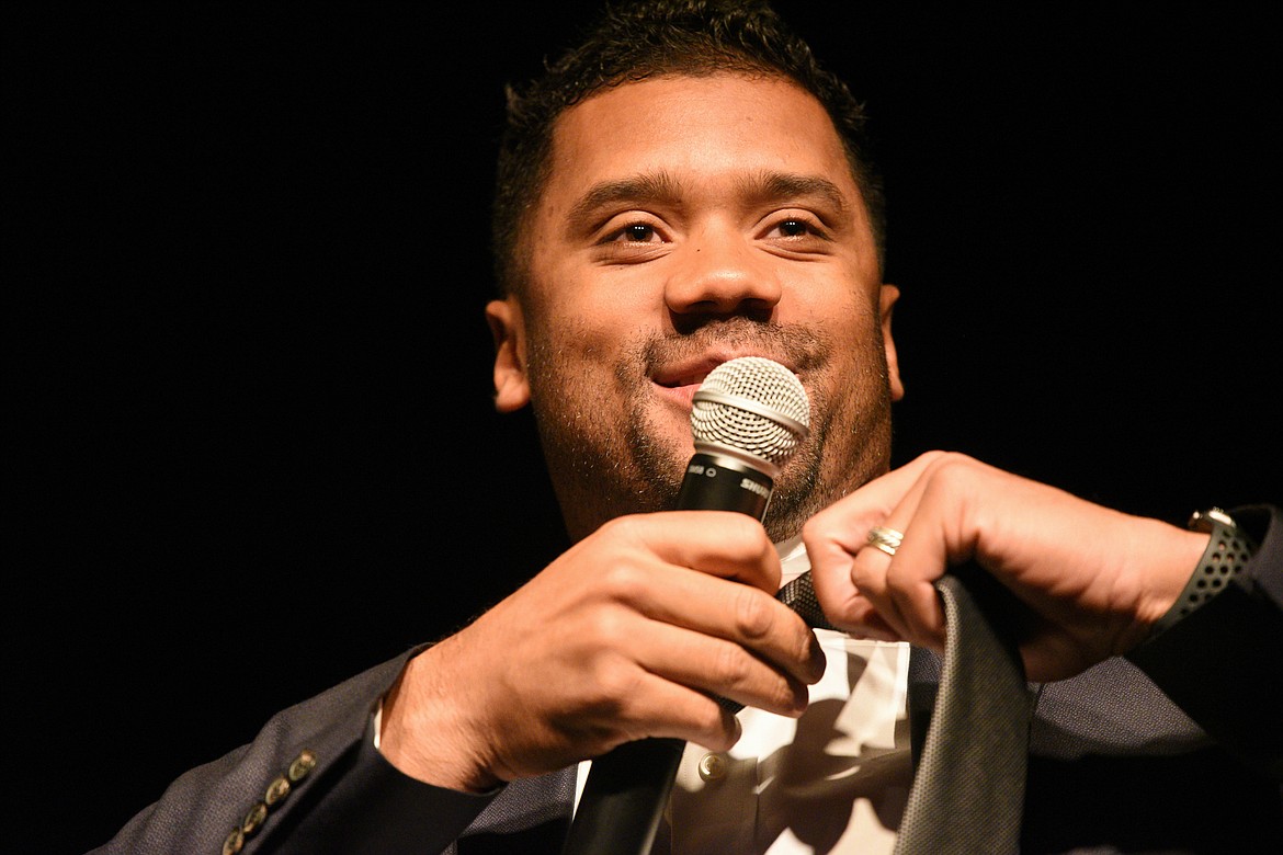 Seattle Seahawks quarterback Russell Wilson jokingly removes his tie to appear more relaxed and then throws it into the crowd at an event held by Stillwater Christian School at the Flathead County Fairgrounds in Kalispell on Wednesday. (Casey Kreider/Daily Inter Lake)