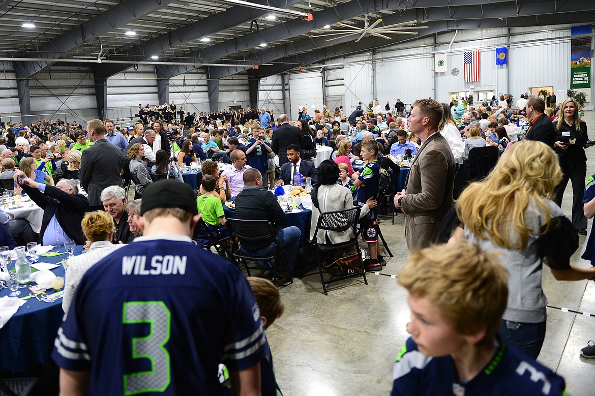 Fans of Seattle Seahawks quarterback Russell Wilson gather around his table for photo opportunities at an event held by Stillwater Christian School at the Flathead County Fairgrounds in Kalispell on Wednesday. (Casey Kreider/Daily Inter Lake)