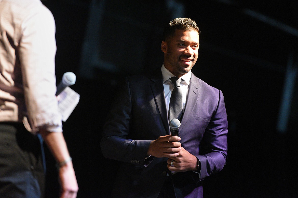 Seattle Seahawks quarterback Russell Wilson is introduced by Darnay Tripp at an event held by Stillwater Christian School at the Flathead County Fairgrounds in Kalispell on Wednesday. Tripp is sports director at KREM 2 in Spokane, Washington. (Casey Kreider/Daily Inter Lake)