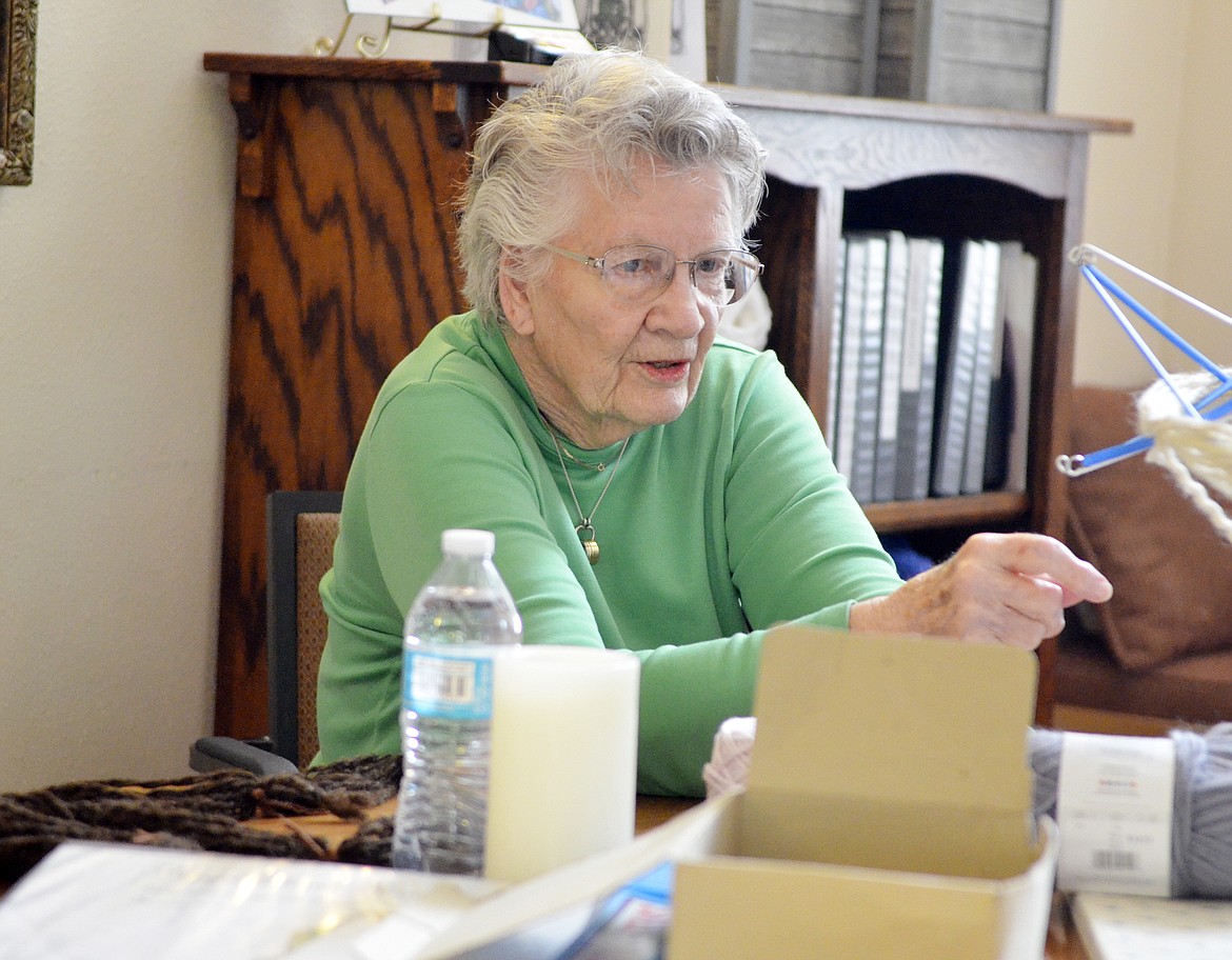 Mariel Cole provides guidance as yarn she previously spun is wound into balls so it is ready to be used for knitting by the Knit Wits group, which makes items that are given to those in-need. The group meets twice a week at The Springs at Whitefish. (Heidi Desch/Whitefish Pilot)