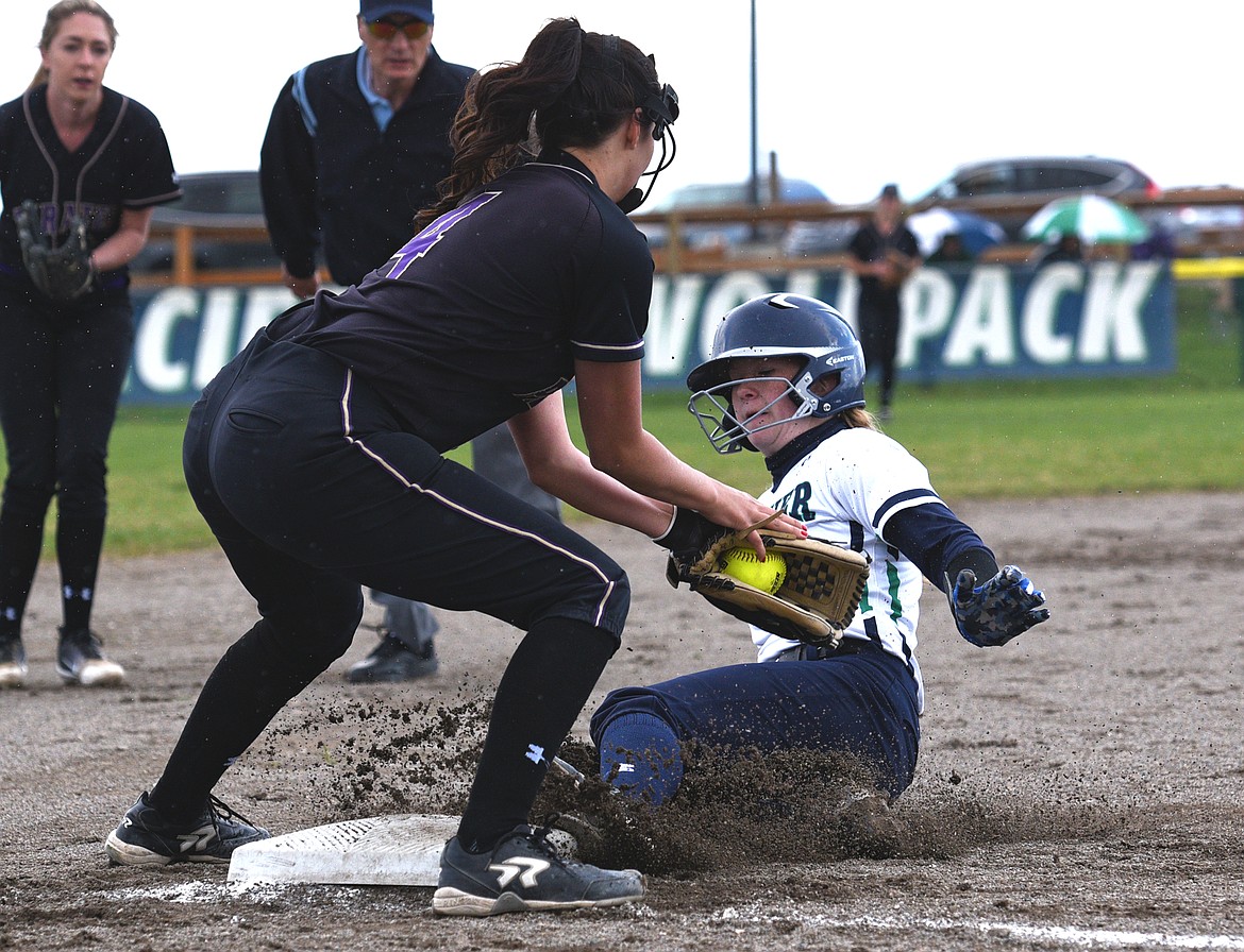 Glacier's Kynzie Mohl slides safely into third under the tag by Polson third baseman Olivia Perez in the first inning. (Casey Kreider/Daily Inter Lake)