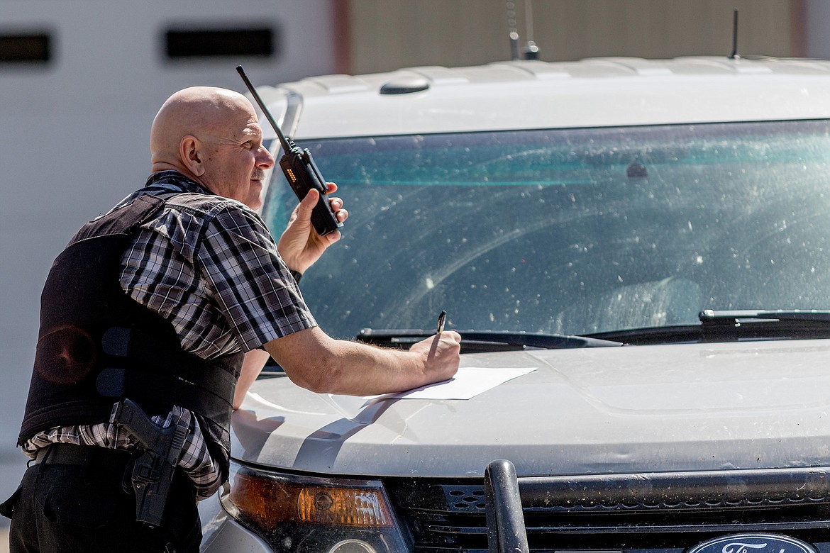 Lincoln County Under Sheriff Brian Griffeth monitors radio traffic at a command post set up at Fisher River Fire Station No. 1 on Wednesday.
(John Blodgett/The Western News)