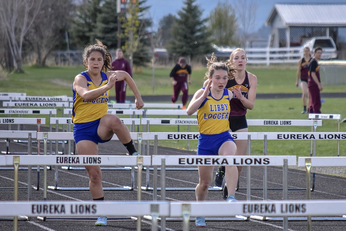Libby juniors Isabella Hollingsworth and Emma Gruber and Troy sophomore Ella Pierce compete in the 100m hurdles at the Lincoln County Track Meet Tuesday. Gruber won the event in 17.29 seconds, and Hollingsworth set a season record of 17.59 seconds. (Benjamin Kibbey/The Western News)