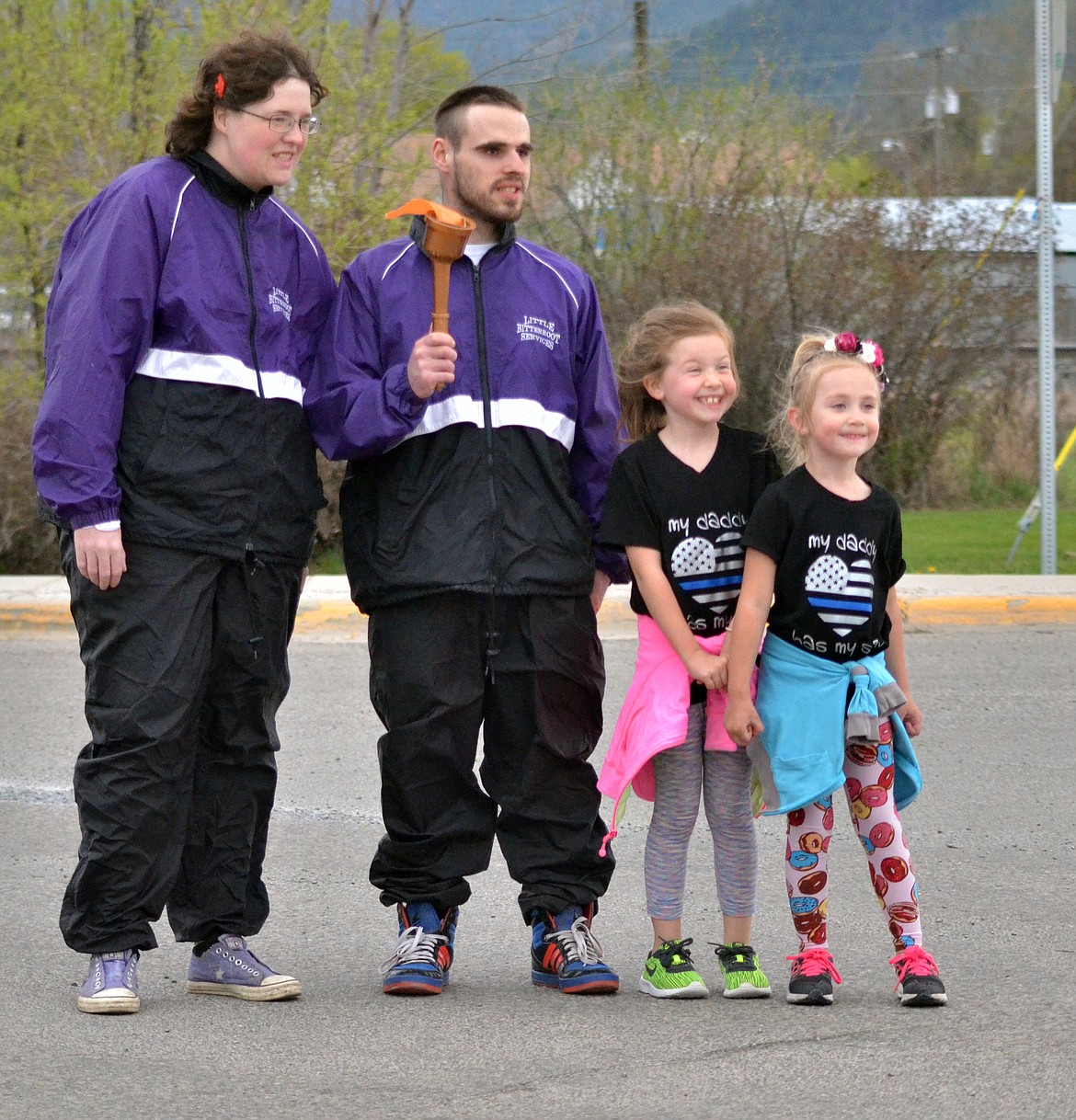 Kendall and Cooper Spurr pass the torch along to Danni Dagiau and Scott Ginther in front of The Circle in Plains for the last leg of the race (Erin Jusseaume/ Clark Fork Valley Press)