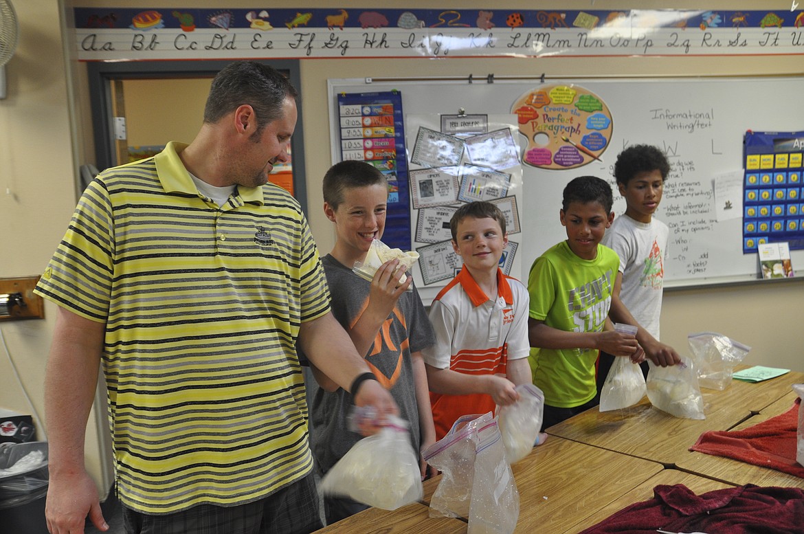 PICTURED LEFT to right are Ryan Gage, Polson Middle School sixth grader Taegen Gage, Linderman Elementary third grader Strider Gage, Polson Middle School sixth grader Anthony Lichtenberg and Polson Middle School eighth grader Tra Lichtenberg. The group shakes large plastic bags containing an ice cream mixture in smaller bags at Linderman&#146;s STEAM night Thursday, April 26. (Ashley Fox/Lake County Leader)