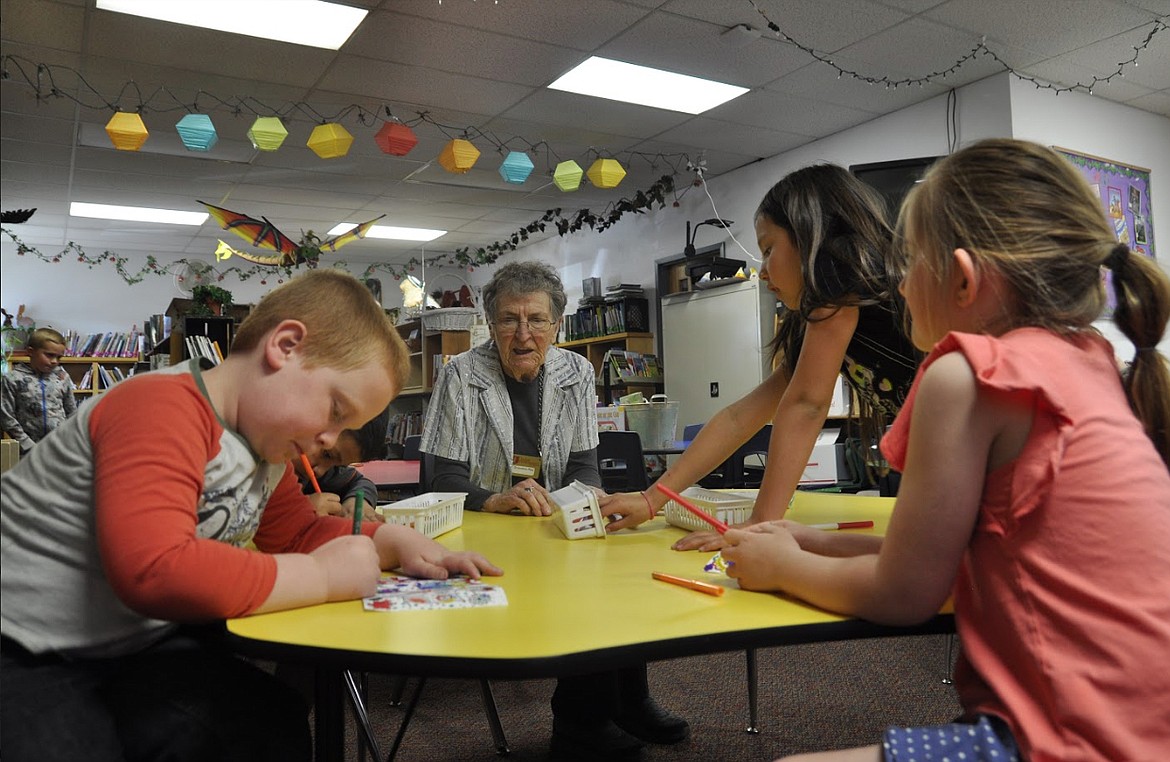 KNOWN AS &#147;Grandma Rita,&#148; Rita Gergerich visits with children from Cherry Valley Elementary in Polson. Gergerich is part of a foster grandparent program that is coming to an end this school year.