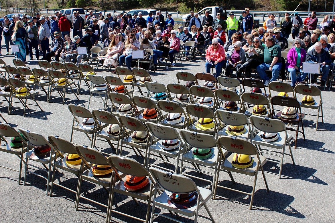 The helmets of the 91 victims displayed in front of the memorial and crowd in Big Creek.