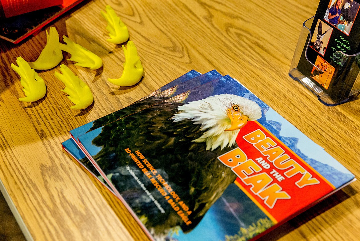 Plastic prosthetic bald eagle beaks sit next to &#147;Beauty and the Beak&#148; -- the book about the beak&#146;s design for use in the rehabilitation of Beauty, a bald eagle rescued by Birds of Prey Northwest -- at a presentation at Libby Dam Saturday, April 28, 2018. (John Blodgett/The Western News)