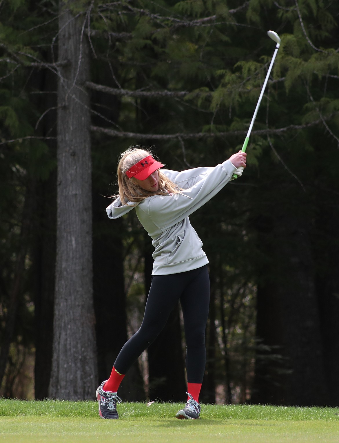 (Photo by ERIC PLUMMER)
Sandpoint freshman Hattie Larson rips an iron shot on Monday at The Idaho Club.