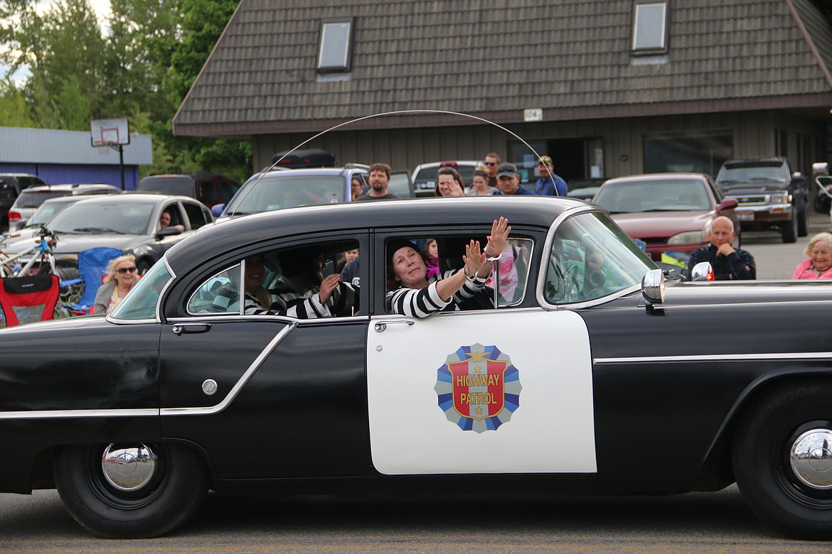 (Photo by MARY MALONE)&quot;Prisoners&quot; plead for mercy as they are driven away in this classic police car during the Lost in the '50s car parade on Friday.