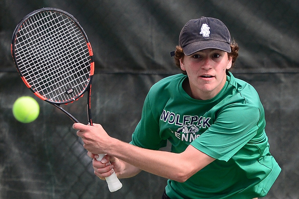 Glacier's Tyler Keller hits a return in a doubles match with Bozeman's Jackson Pedersen and Andrija Martinovic in the Class AA State Tennis Tournament at Flathead Valley Community College in Kalispell on Friday. (Casey Kreider/Daily Inter Lake)