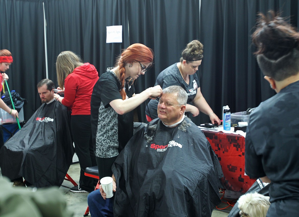 Air Force veteran Robert Spaulding of Plummer closes his eyes as Sport Clips Haircuts manager Alexiah Vaage gently trims a little off the side Saturday morning in the Jacklin Building of the Kootenai County Fairgrounds during the North Idaho Veterans Stand Down. About 500 veterans and their loved ones came through the Stand Down, which has served more than 25,000 veterans since it began 25 years ago. (DEVIN WEEKS/Press)