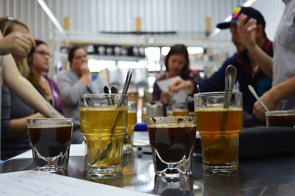 The cupping event at Fieldheads included a taste test where the top of the coffee must be scraped with spoons and the surface grounds removed before slurping a taste from a spoon.