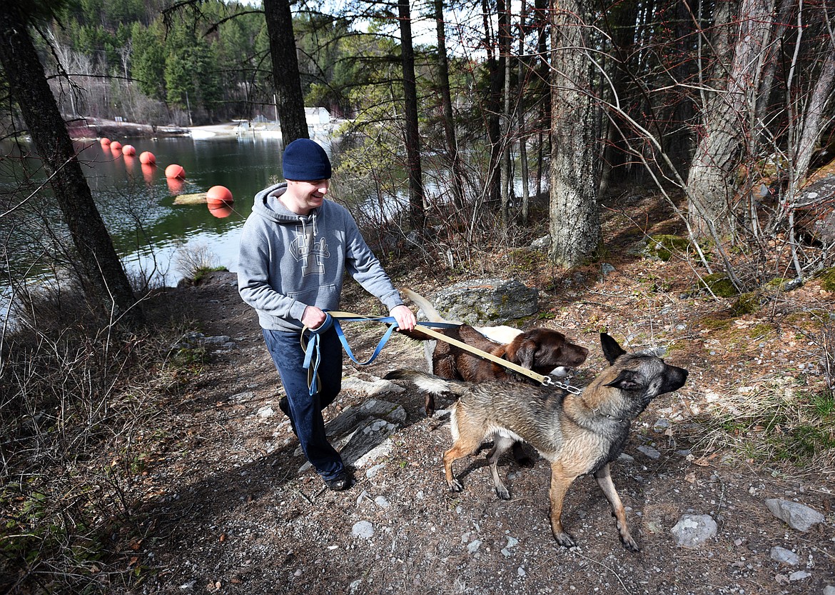 Officer Jason Parce takes his dogs Chester, JJ and Cairo down to the waters edge for a bit of play time.(Brenda Ahearn/Daily Inter Lake)