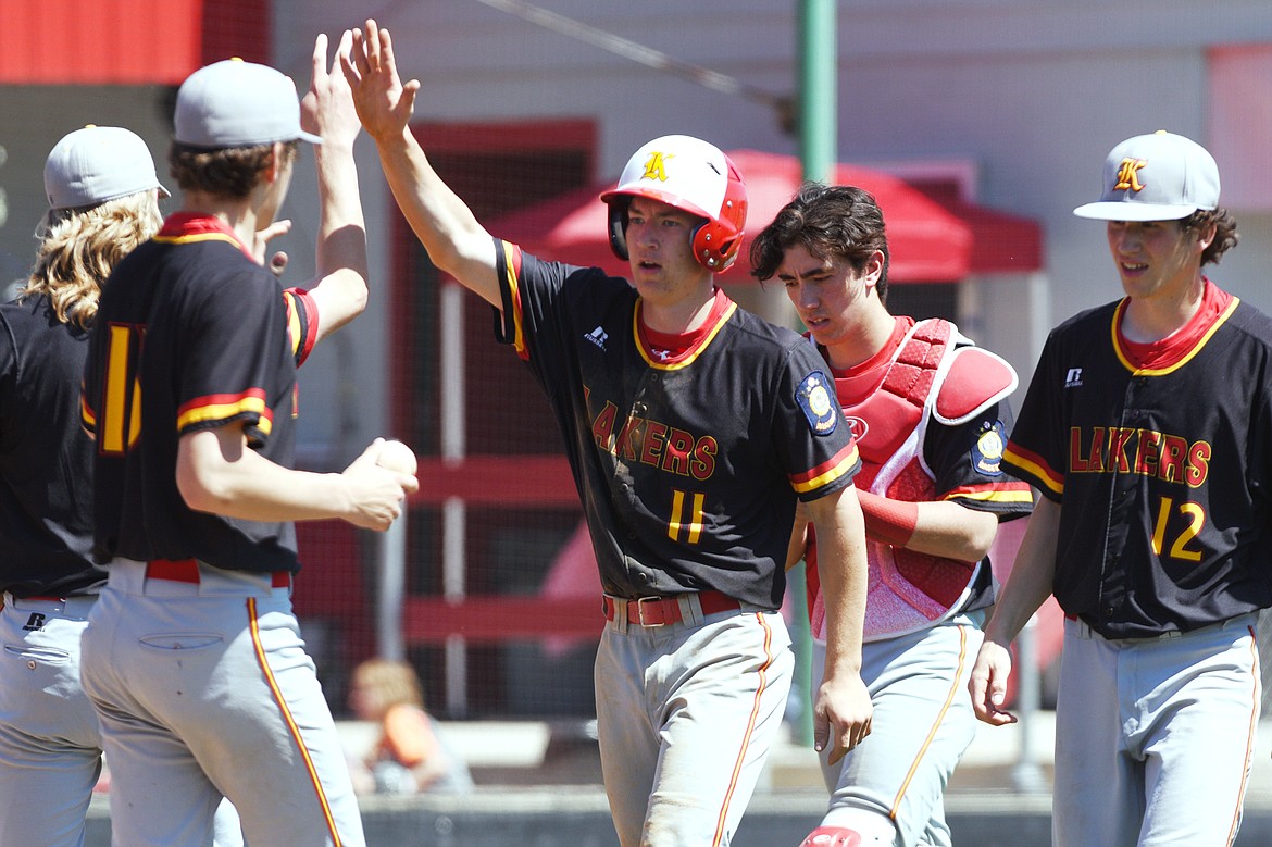 Kalispell's Brandon Jordan is congratulated by teammates after scoring a run in the bottom of the fifth against Helena on Saturday. (Casey Kreider/Daily Inter Lake)