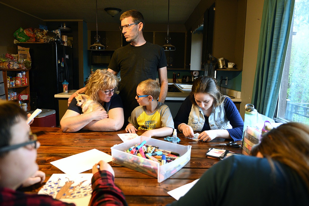 Clockwise from top left, Tamara Horton, husband Nate Horton, daughter Jasmine, daughter T.K. and son Evan create handmade cards for their oldest sister, Florence, who is married and lives in Arizona. (Casey Kreider/Daily Inter Lake)