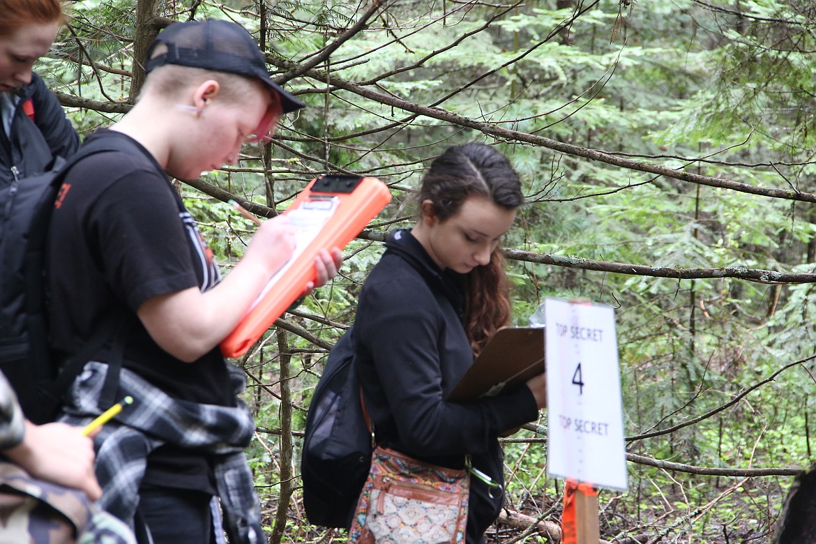 (Photo by MARY MALONE)
Priest River Lamanna High School junior Milo Edwards, left, and Post Falls Middle School eighth-grader Hailey Sims, right, mark down their answers for tree number four in the tree identification portion of the Idaho State Forestry Contest on Thursday, held at the Delay Farm in Careywood.