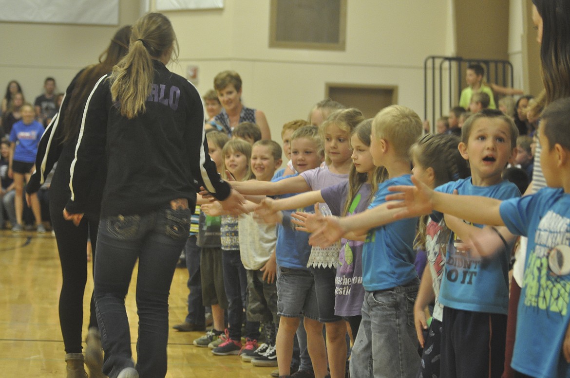 CHARLO SPECIAL OLYMPICS team members give 'high-fives' to elementary students at a Respect Rally Monday just before the athletes gear up for the Special Olympics games in Great Falls. (Ashley Fox/Lake County Leader)