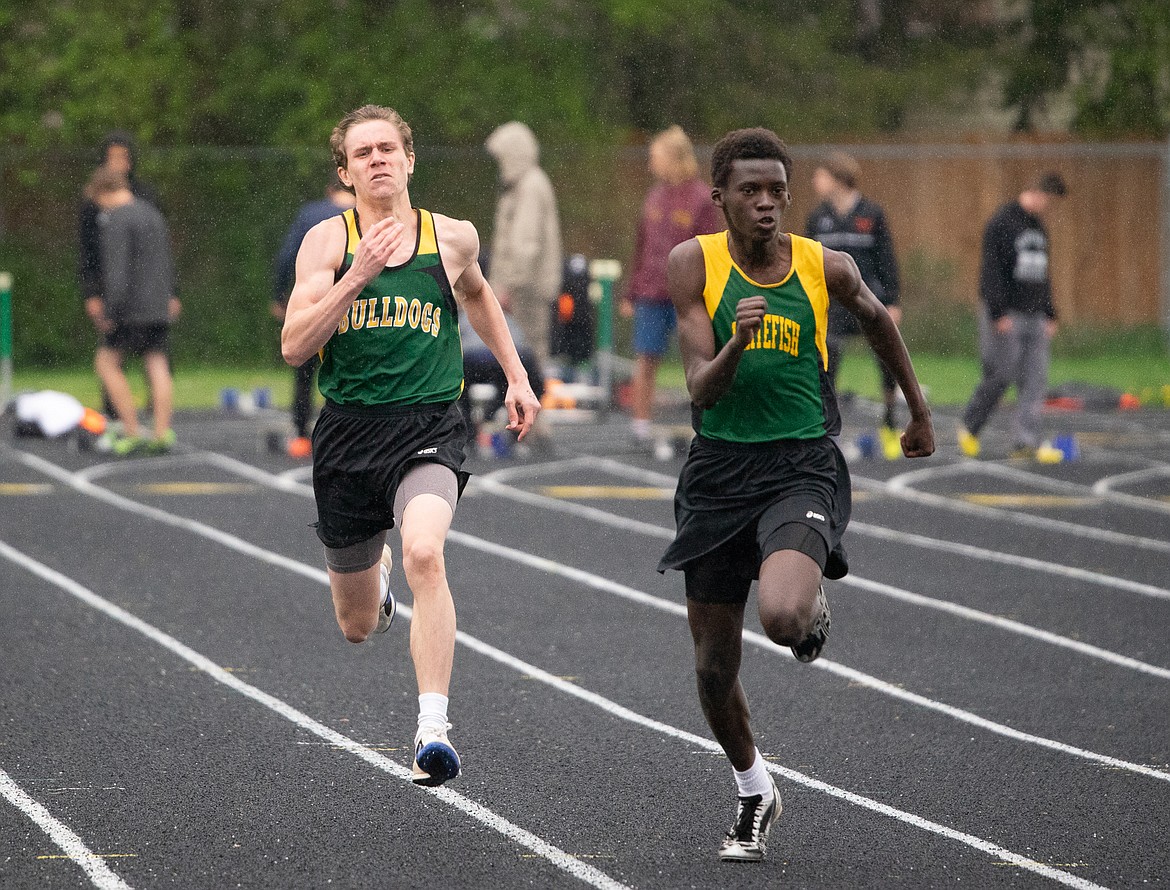 Port Nugent and Marvin Kimera race through the rain in the 100 meter dash in Thursday&#146;s dual against Flathead at Whitefish High School. (Daniel McKay photos/Whitefish Pilot)